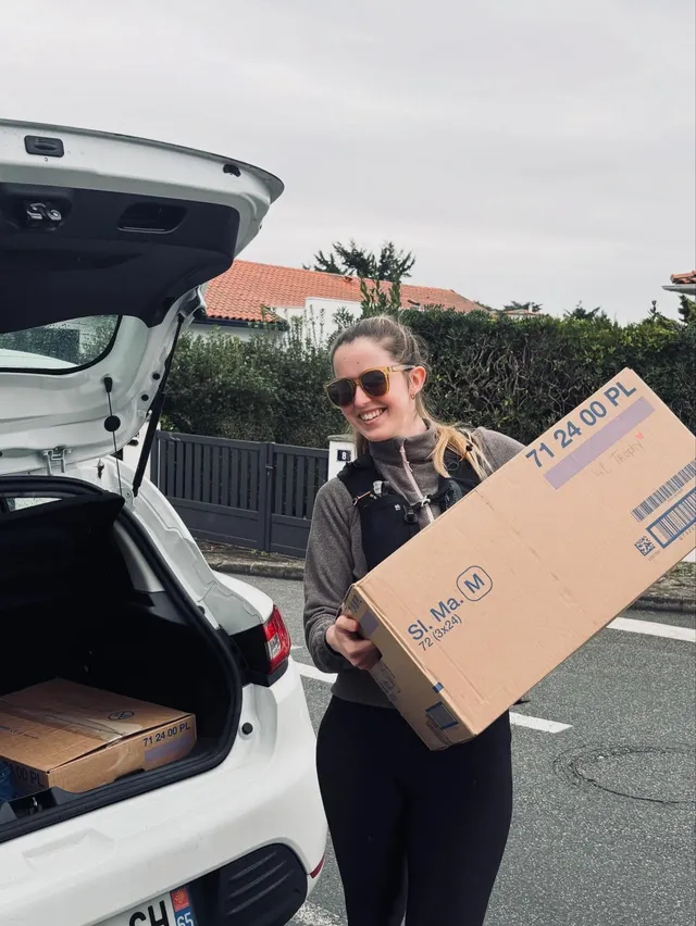 Louise, tout sourire, avec un colis pour la préparation